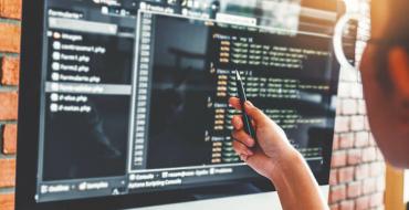 Hombre revisando código html en una pantalla
