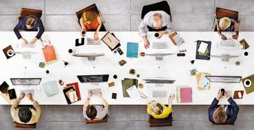 Mesa rectangular con un equipo de personas trabajando