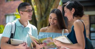 Grupo de jóvenes conversando y revisando apuntes en sus cuadernos