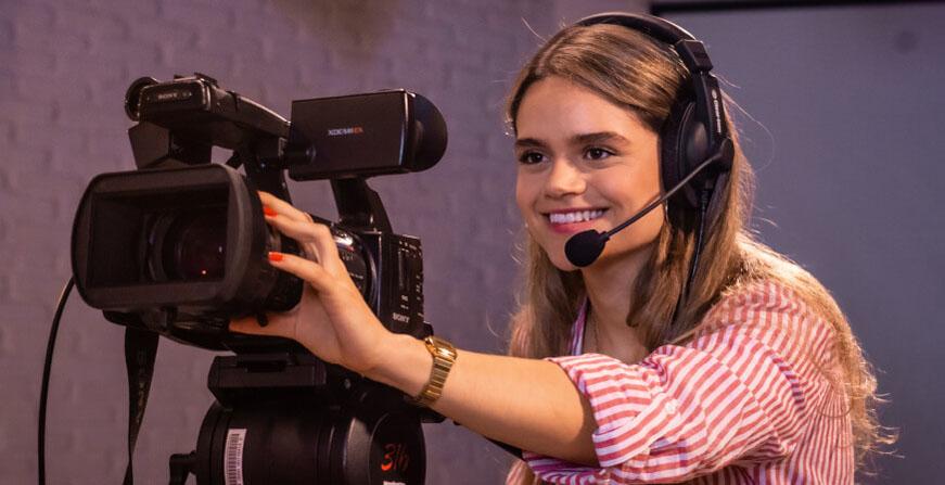 Joven estudiante con cámara de video y micrófono