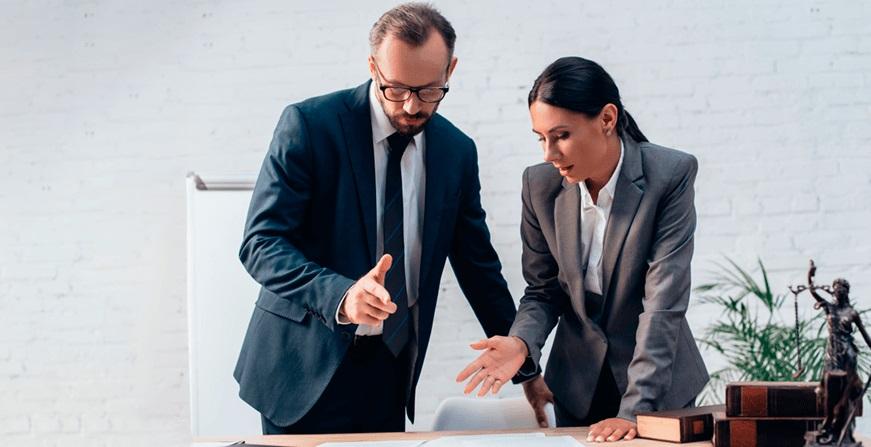 Mujer y Hombre conversando y revisando documentos