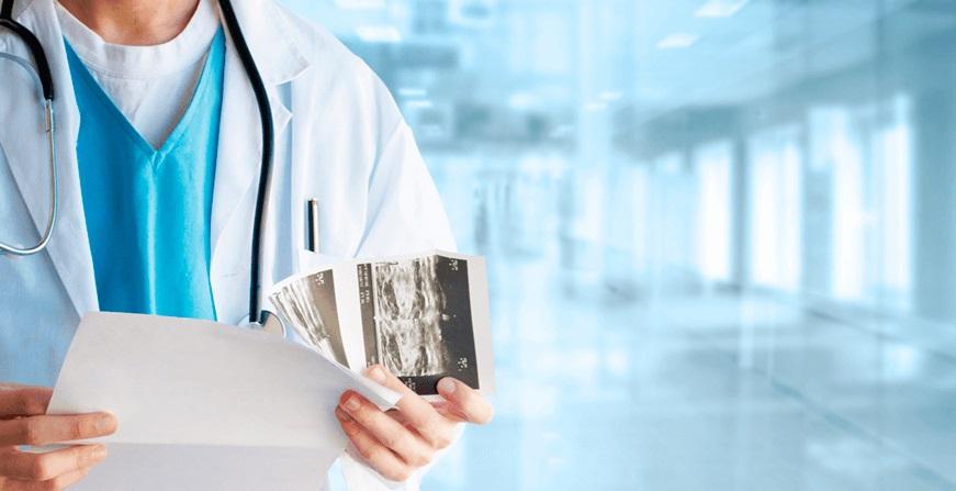 Médico revisando ecografía y resultado de examen